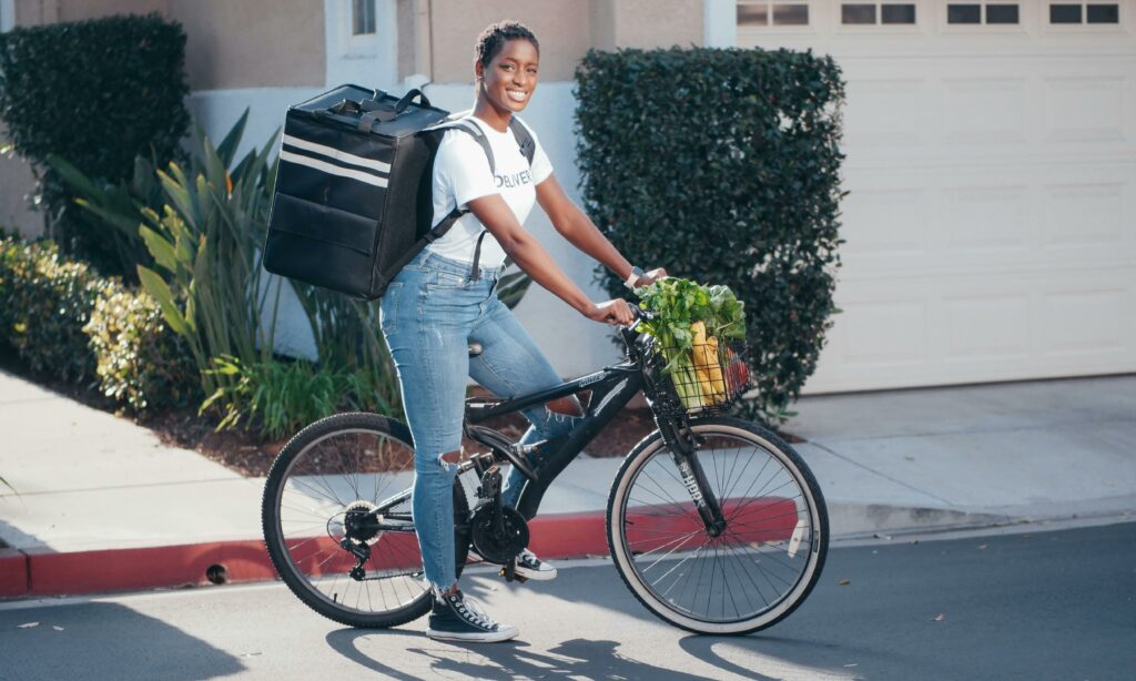 A Woman with Insulated Food Delivery Backpack Sitting on a Bike